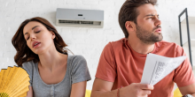 man and woman fanning themselves in their overly hot home