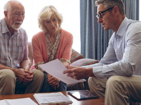 older couple going over report with man in their home