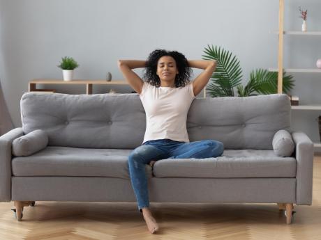 healthy woman sitting on a couch in a clean house