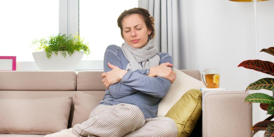 woman sitting on a couch looking cold