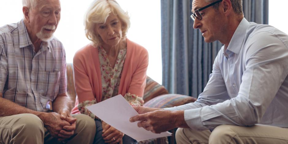 older couple going over report with man in their home older couple going over report with man in their home