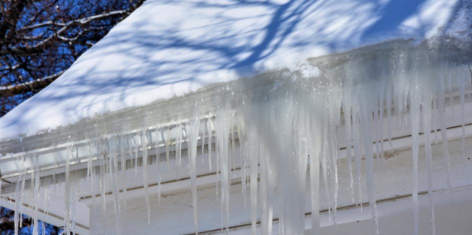 ice dam collecting on edge of snowy roof