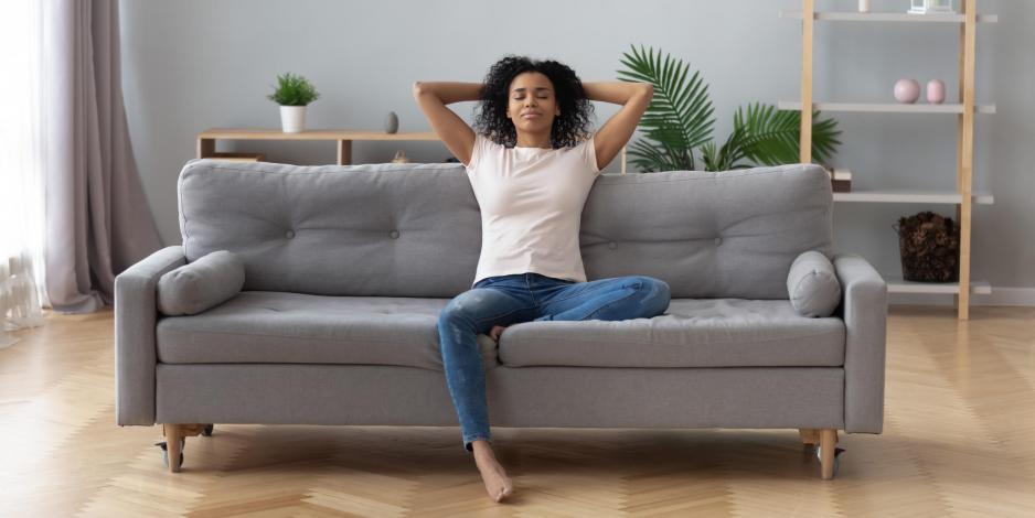 healthy woman sitting on a couch in a clean house